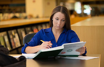 A student studies in the library at 鶹Ӱ