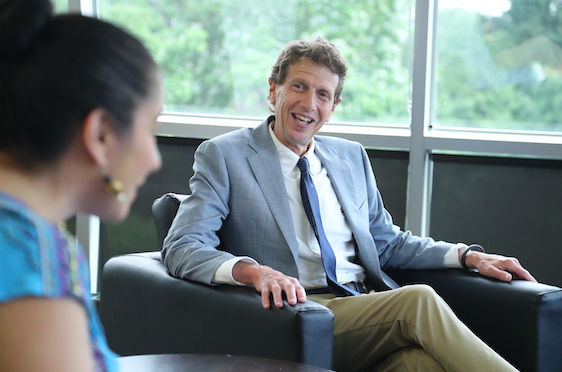 President Gittell sitting in library and talking with faculty