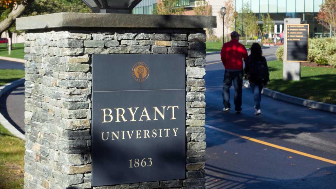 Parents of a student walk past the Bryant stone pillar sign