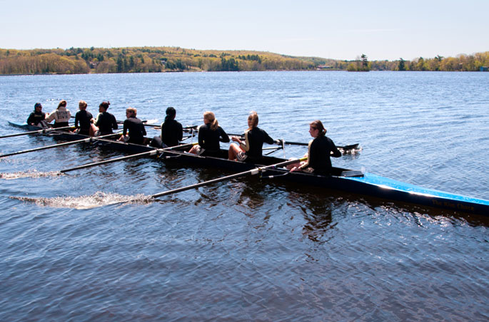 The Bryant rowing team practices on a nearby body of water.