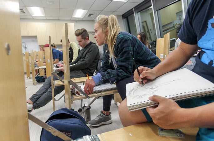 A group of Bryant students sit in an art class.