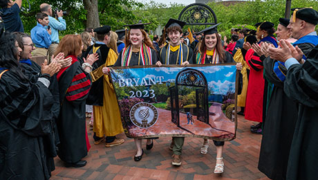 Three students march with the Class of 2023 during 鶹Ӱ's undergraduate commencement exercises.
